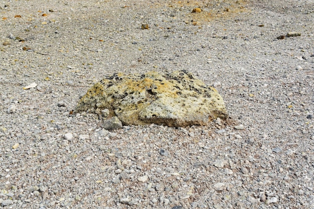 Volcanic bomb among the tephra on the slope of the volcano closeup