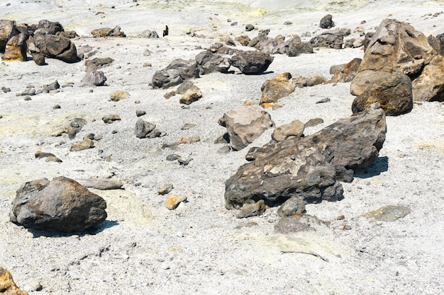 Volcanic bombs among the tephra in a fumarole field on the slope of a volcano