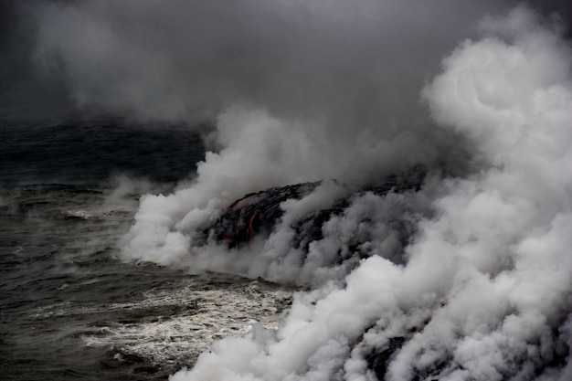 写真 海の岩層から噴火する火山