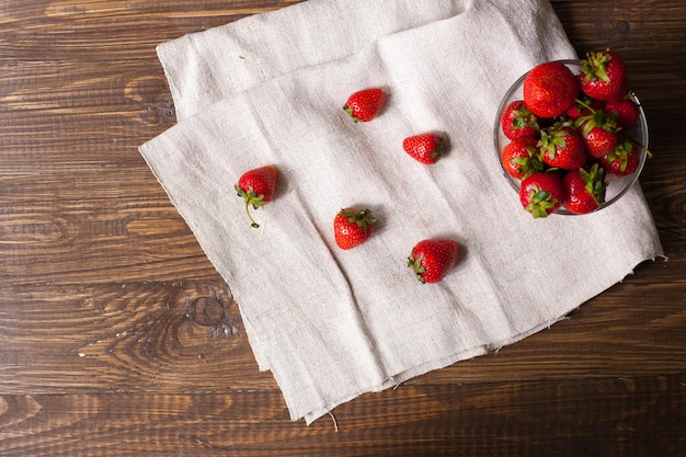 Volglazen kom verse rijpe srawberries en keukenhanddoek met heerlijke aardbeien erop