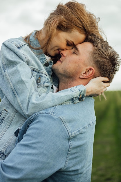 Volgroeide jonge familie schoot in denim vrijetijdskleding rond in het park, hand in hand op warme lentedag