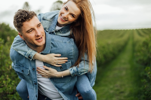 Volgroeide jonge familie schoot in denim vrijetijdskleding rond in het park, hand in hand op warme lentedag