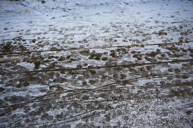 volgt asfaltsneeuw, ijs, sporen van mensen van schoenen op sneeuw, sneeuwruimweer