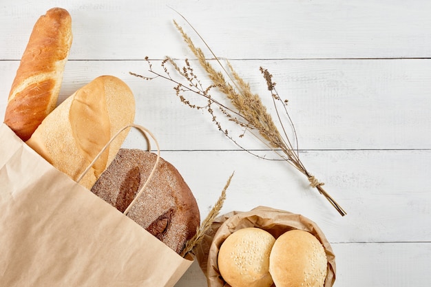 Volkoren brood in ecologie papieren zak op witte houten achtergrond zero waste recycling