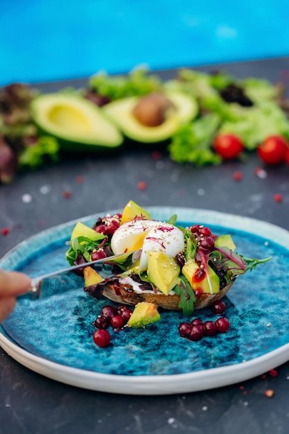 Volkoren geroosterd brood met avocado gepocheerd ei zachte kaas en mix salade Gezonde voeding eten ontbijt