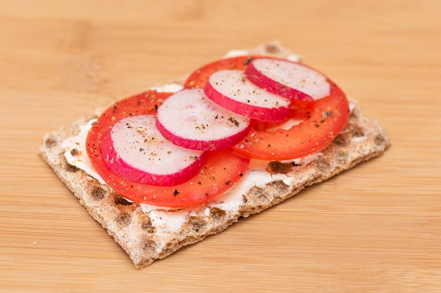 Volkoren knäckebröd met tomatenroomkaas en radijs