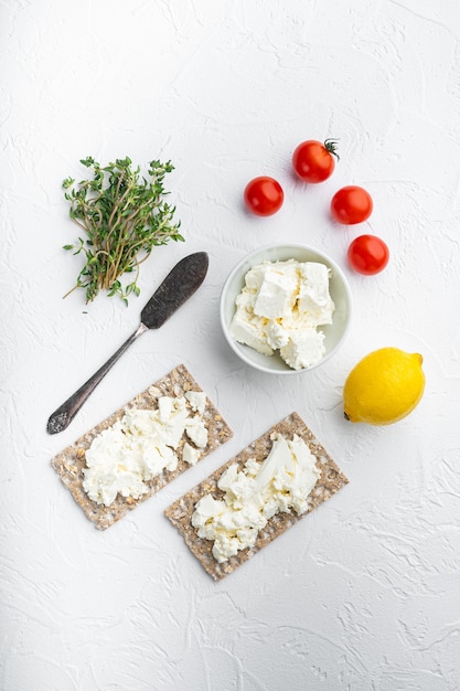 Volkoren rogge knäckebröd met roomkaas set, op witte stenen tafel, bovenaanzicht plat lag