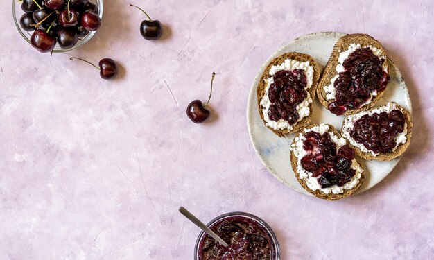 Volkoren toast met ricotta en zelfgemaakte zoete kersenjam op plaat bovenaanzicht