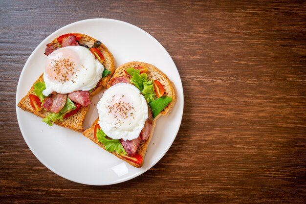 Foto volkorenbrood geroosterd met groente, spek en ei of egg benedict als ontbijt