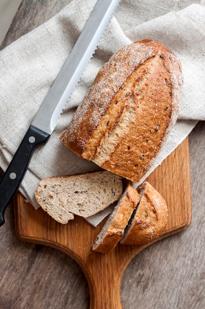 Volkorenbrood met plakjes op houten bord op keukentafel