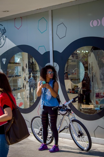 Foto volle lengte van een vrouw die op een fiets staat in de stad