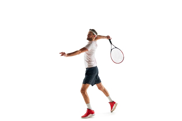 volle lengte van jonge man in sportkleding tennisspeler oefent het raken van de bal met racket geïsoleerd