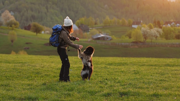 Volle lengte van vrouw die met hond speelt op het gras