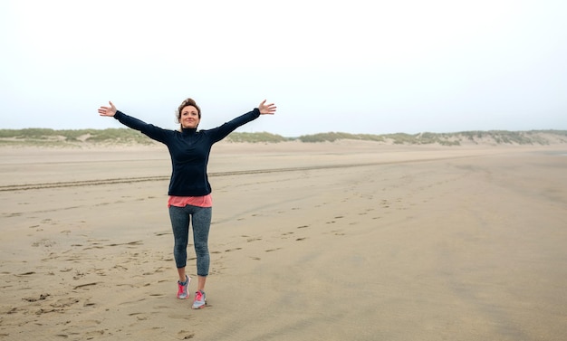 Foto volle lengte van vrouw die op het strand staat tegen de lucht