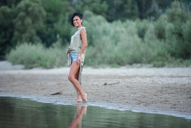 Volle lengte van vrouw die op het strand staat
