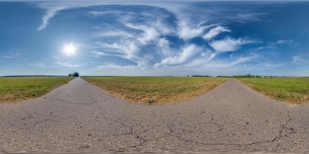 Foto volledig bolvormig naadloos hdri 360-panoramabeeld op verkeersvrije oude asfaltweg met scheuren tussen velden met lucht en wolken in rechthoekige projectie vr ar-inhoud kan worden gebruikt als luchtvervanging