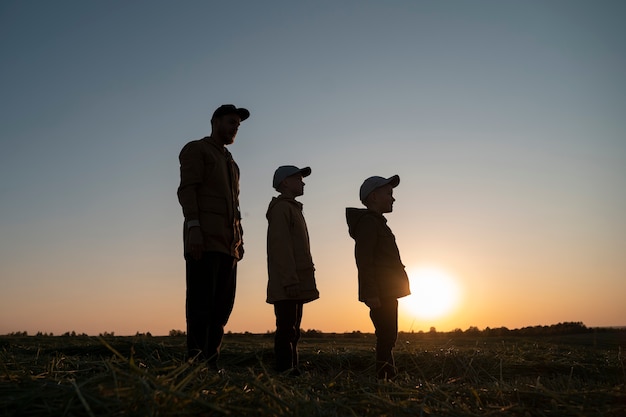 Foto volledig geschoten familiesilhouet met plezier bij zonsondergang