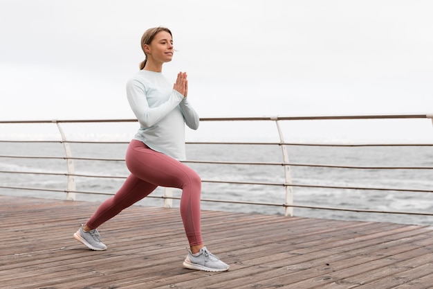 Foto volledig geschoten gelukkige vrouw die yoga doet