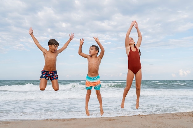Foto volledig geschoten kleine kinderen die plezier hebben op het strand