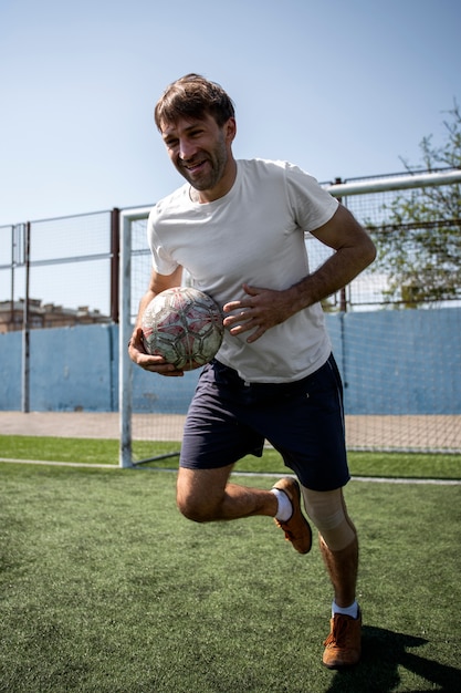 Foto volledig geschoten man aan het voetballen