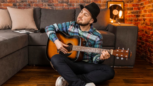 Foto volledig geschoten man met hoed gitaar spelen