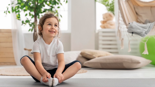 Foto volledig geschoten meisje op yogamat