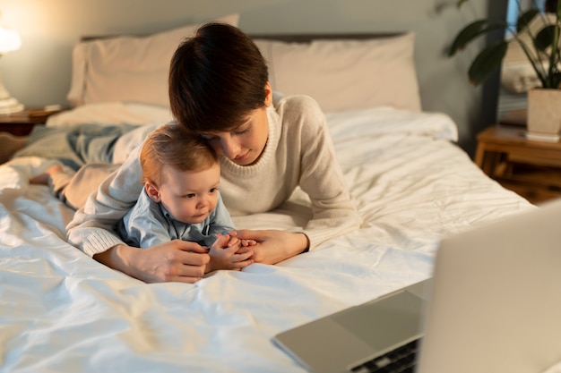 Foto volledig geschoten moeder en baby die in bed liggen