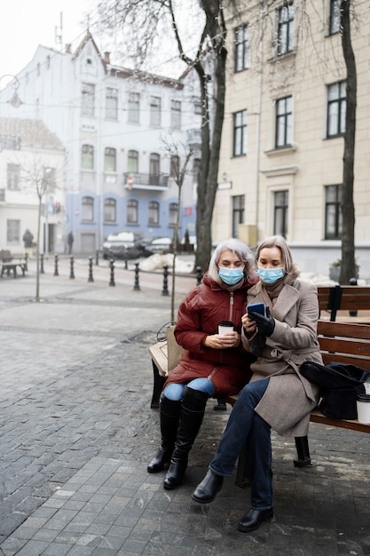 Foto volledig geschoten oude vrouwen die op bank zitten