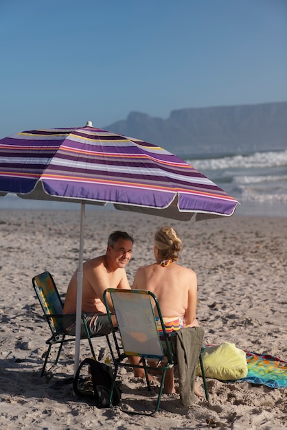 Foto volledig geschoten senior koppel aan het chatten op het strand