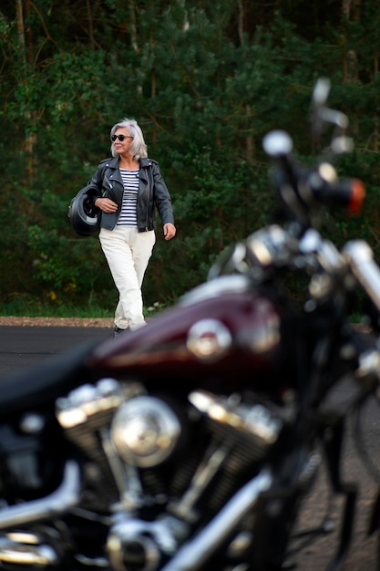 Foto volledig geschoten senior vrouw met motorfiets