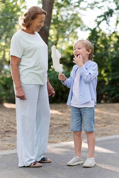 Foto volledig geschoten smileyjong geitje dat suikerspin eet