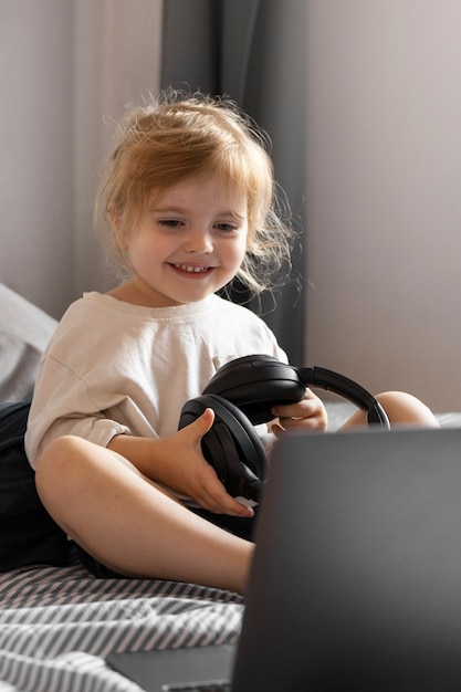 Foto volledig geschoten smileymeisje dat hoofdtelefoons houdt