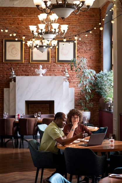 Foto volledig geschoten vrienden die bij restaurant eten