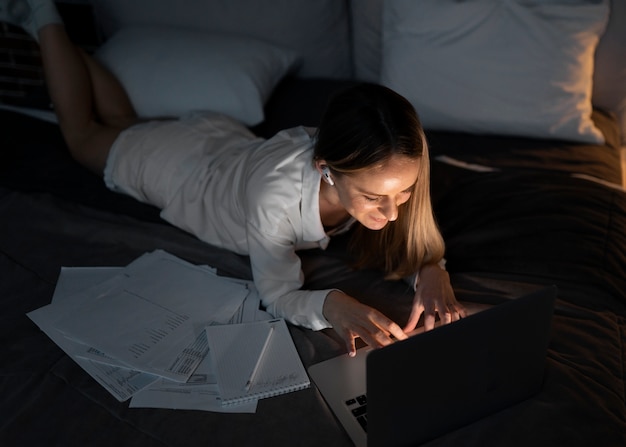 Foto volledig geschoten vrouw die 's avonds laat aan het werk is