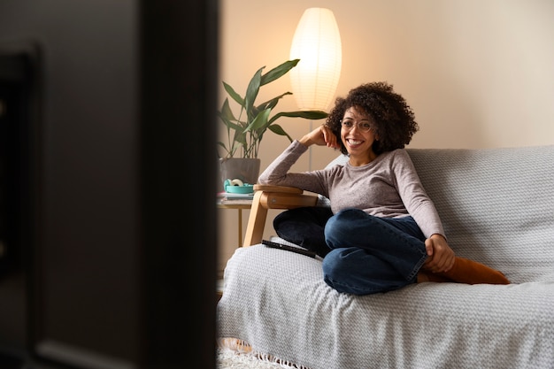 Volledig geschoten vrouw die tv kijkt