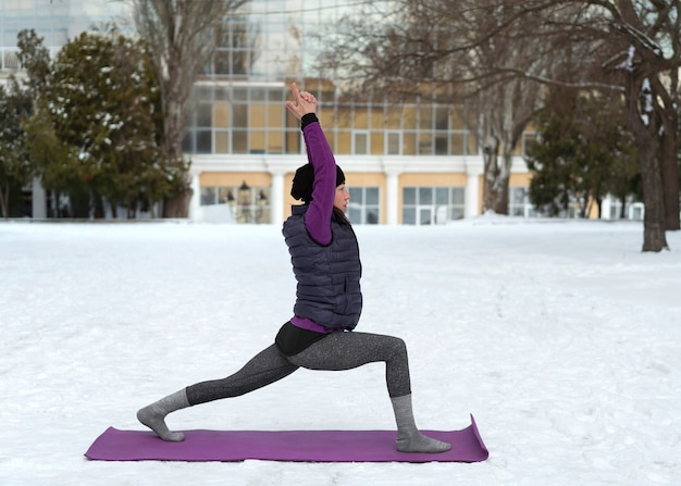Foto volledig geschoten vrouw die yoga doet bij koud weer