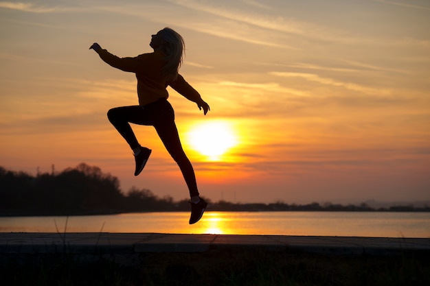 Foto volledig geschoten vrouw die zich voordeed bij zonsondergang