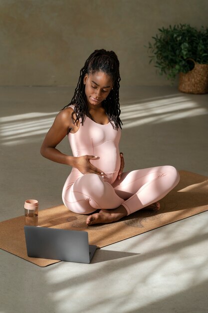 Foto volledig geschoten zwangere vrouw op yogamat