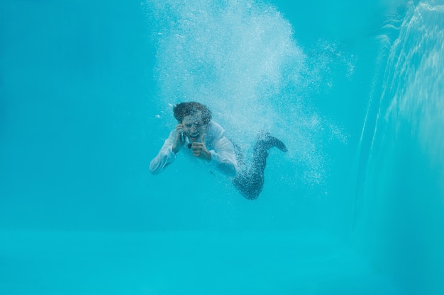 Volledig lengteportret van een jonge man onderwater zwemmen