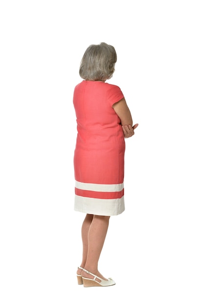 Volledig lengteportret van hogere vrouw in rode kleding, achtermening op witte background