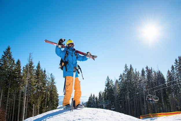 Volledig lengteschot van een skiër die zich bovenop een sneeuwhelling in de bergen bevindt