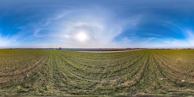 Volledig naadloos bolvormig hdri-panorama 360 graden hoekweergave tussen velden in het vroege voorjaar met zon op heldere hemel met halo in equirectangular projectie klaar voor VR AR-inhoud