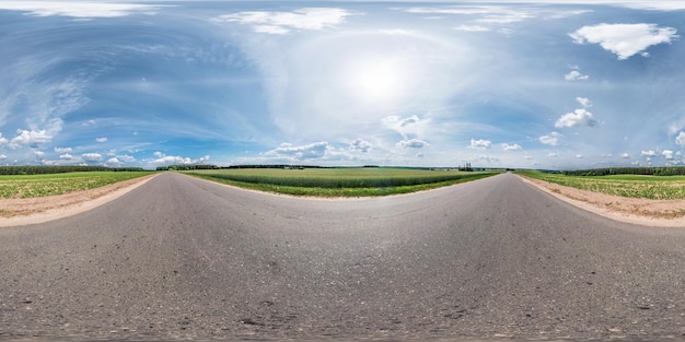 Volledig naadloos bolvormig panorama 360 bij 180 graden hoekzicht op de asfaltweg tussen velden in zonnige zomerdag met halo in rechthoekige projectie skybox VR virtual reality-inhoud