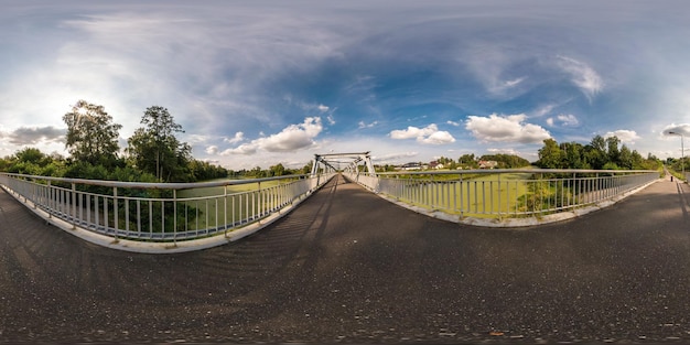 Volledig naadloos bolvormig panorama 360 bij 180 hoek zicht nabij ijzeren stalen frame constructie van voetgangersbrug over de rivier in equirectangular projectie klaar VR virtual reality content
