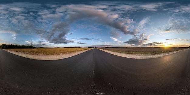 Volledig naadloos bolvormig panorama 360 graden hoekzicht op asfaltweg tussen velden in zomeravond zonsondergang met geweldige wolken in equirectangular projectie skybox VR AR virtual reality-inhoud
