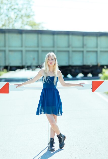 Foto volledig portret van een jonge vrouw die bij een spoorwegovergang staat