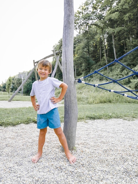 Foto volledig portret van een jongen die bij speelapparatuur in een park staat