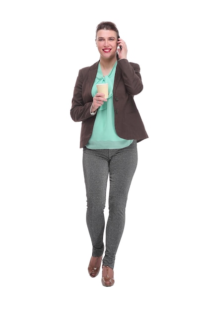 Volledig portret van mooie jonge zakenvrouw in formele kleding lopend en pratend voor mobiele telefoon