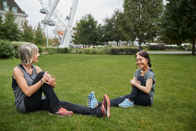 Foto volledig shot vrouwen die zich uitstrekken op gras