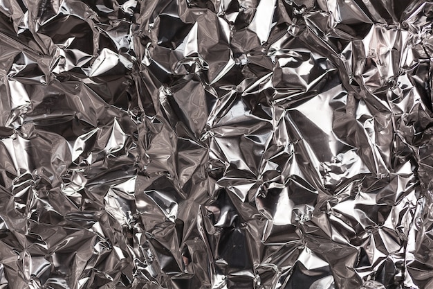 Volledige kaderopname van een vel verfrommelde zilveren aluminiumfolieachtergrond